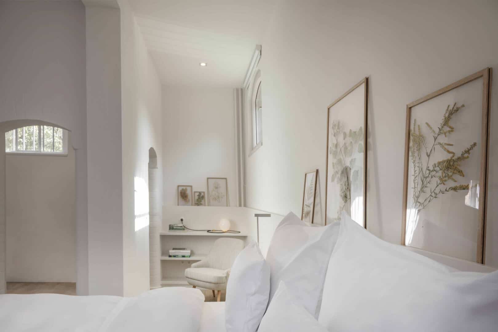 Wilmina Rooms 6 Classic Extended Zimmer im Wilmina Hotel mit entspanntem Lesebereich, Designer-Stuhl und botanischer Wanddekoration