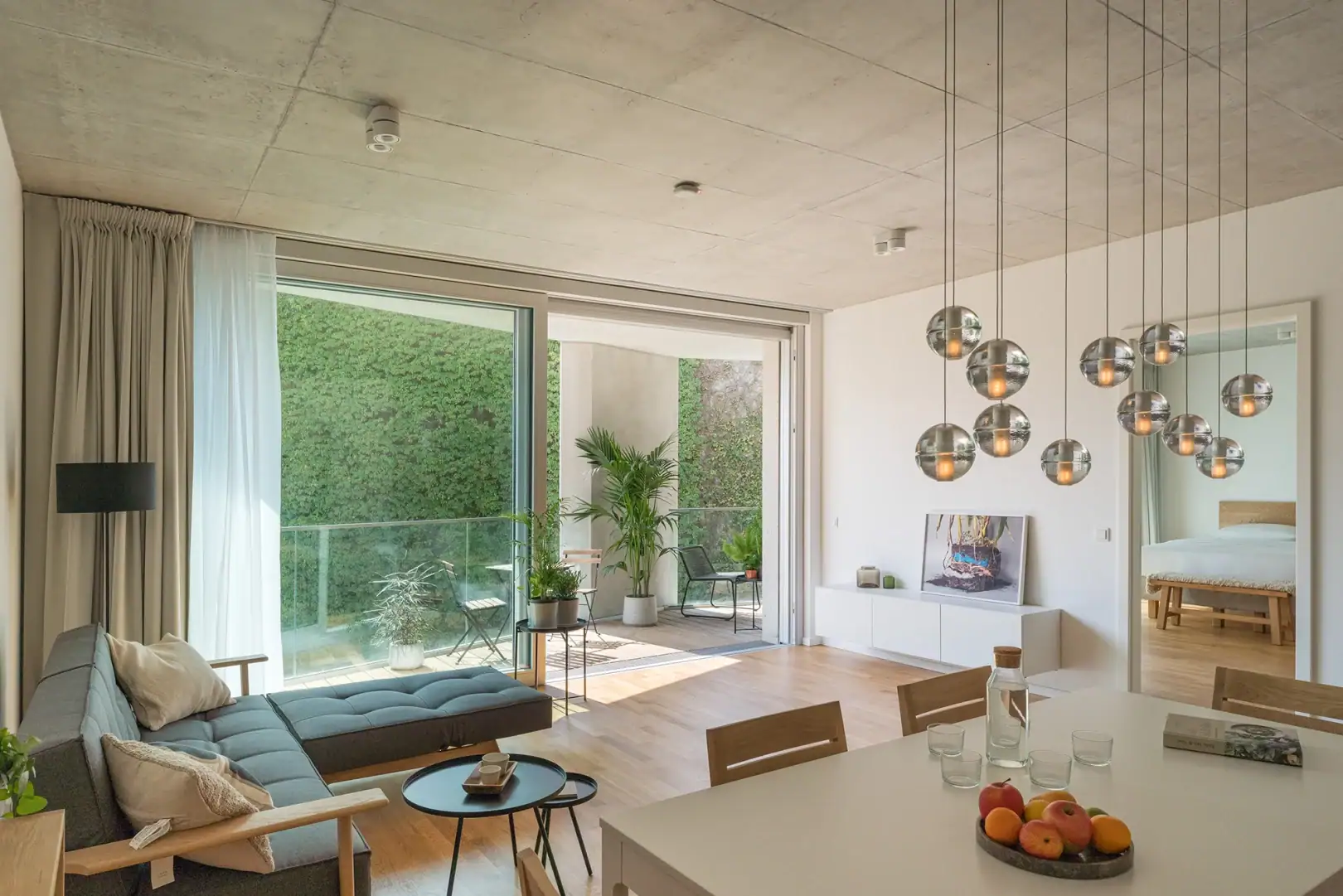 Wilmina Apartments 4 Wohnbereich im Garden Loft 80 mit bodentiefen Fenstern, Echtholzparkett und moderner Einrichtung