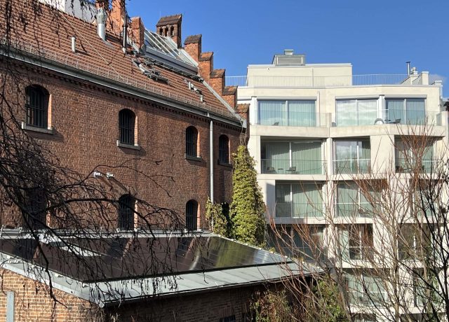 Kontrast zwischen alten Backsteingebäuden und moderner Architektur in Berlin.