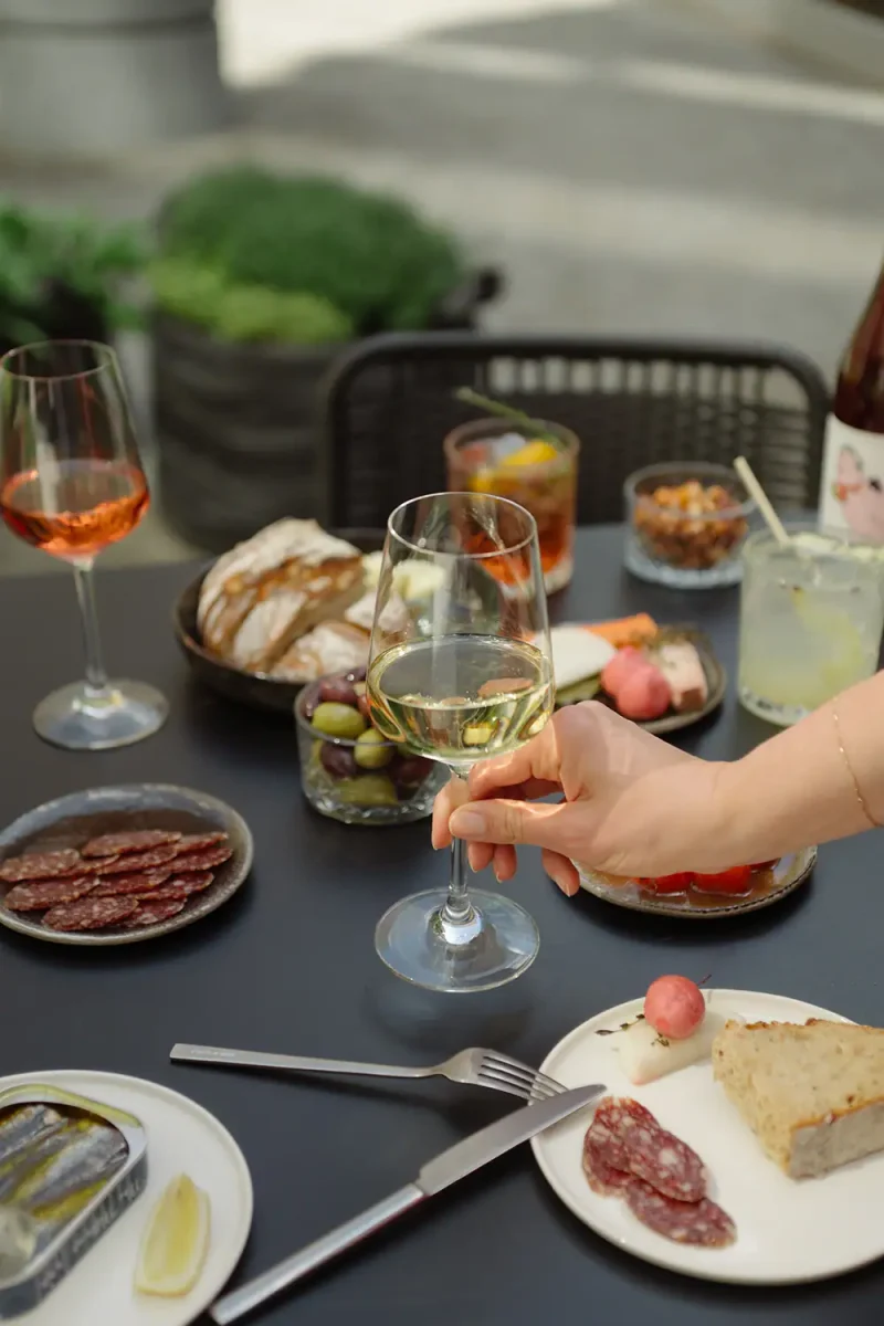 Gedeckter Tisch mit Wein, Käse, Wurst und Snacks bei Wilmina.